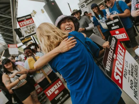 Roteiristas se abraçam durante piquete em frente a NBCUniversal