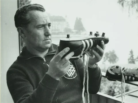 Adolf "Adi" Dassler segura uma chuteira de couro da Adidas