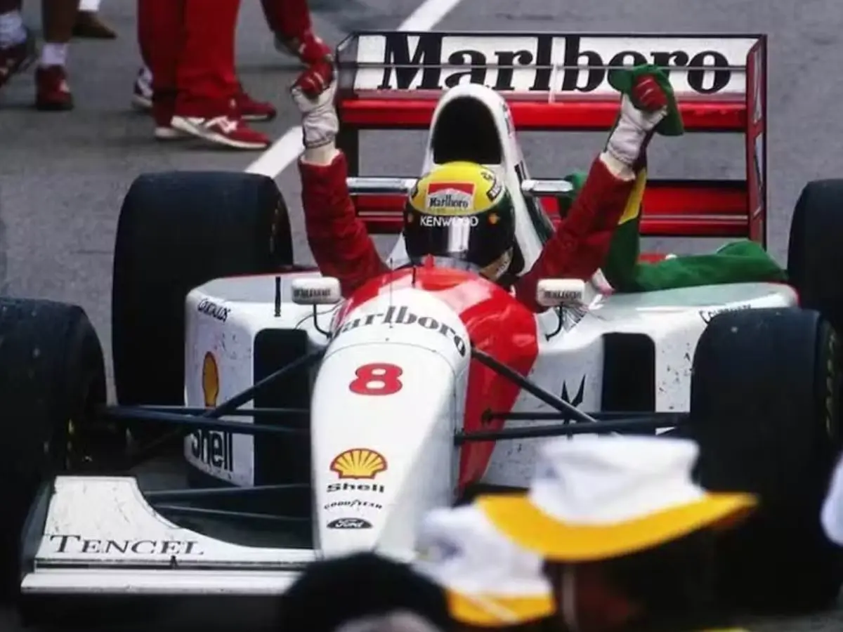 Ayrton Senna ergue as mãos dentro de carro da McLaren